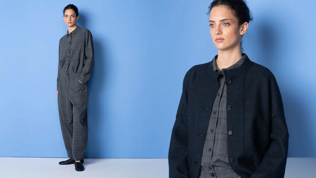 Model wearing gray plaid jumpsuit and dark jacket