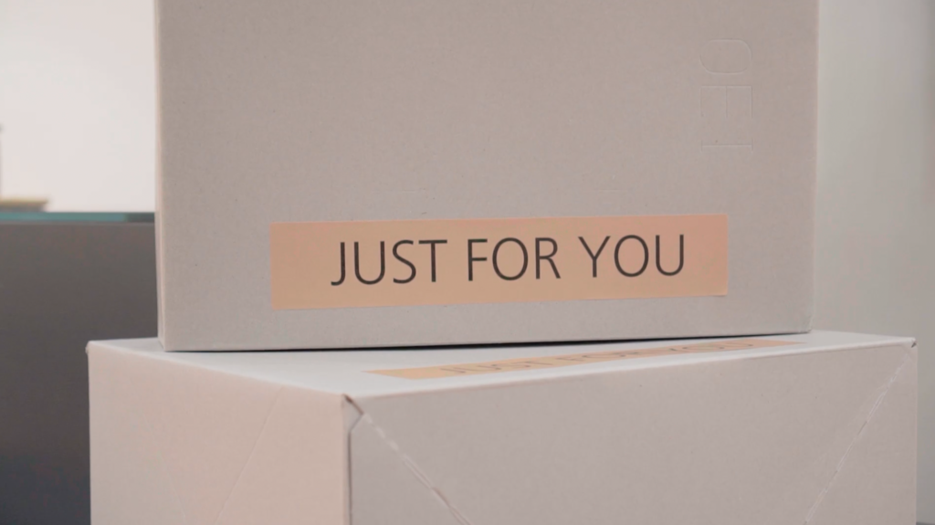 A white shipping box with a label reading "JUST FOR YOU" stacked on another white box.