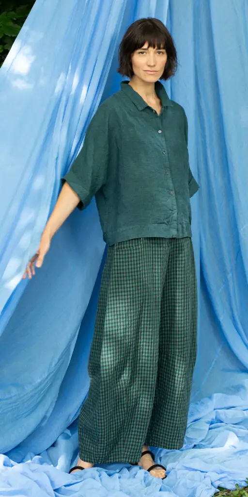Model wearing a green outfit against blue backdrop