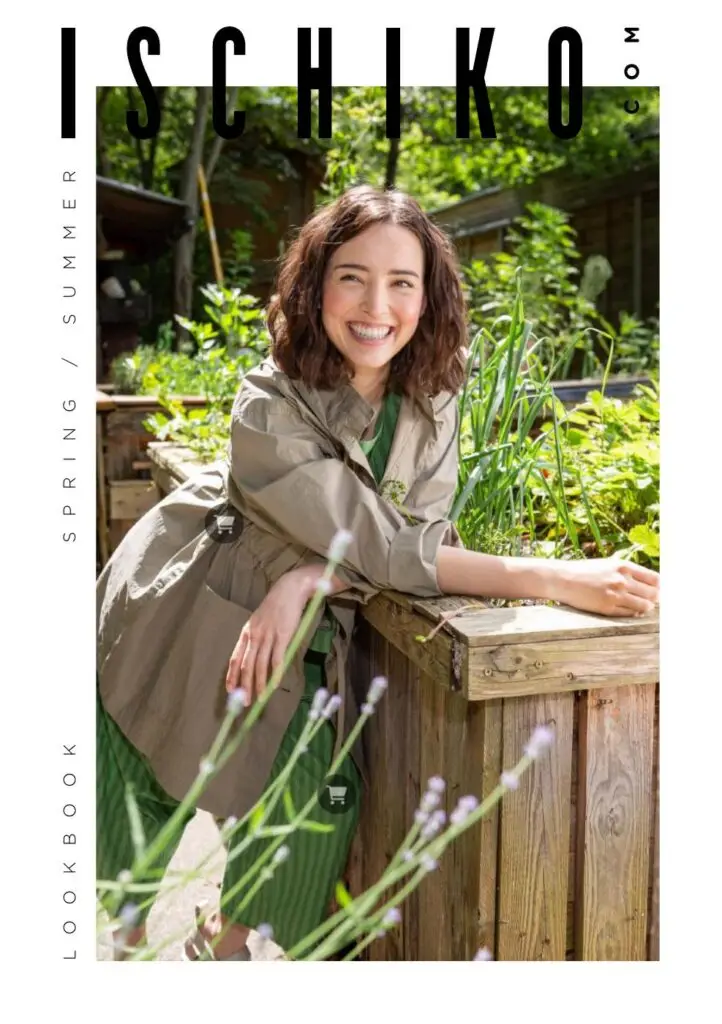 Smiling model in a khaki jacket by a garden bed on the ISCHIKO lookbook cover