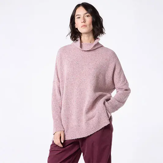 Woman wearing a cozy pink sweater and pants.