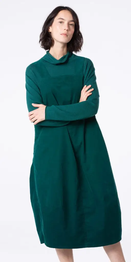 Woman in a green dress posing confidently.