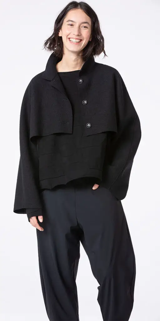 Smiling woman wearing a stylish black outfit.