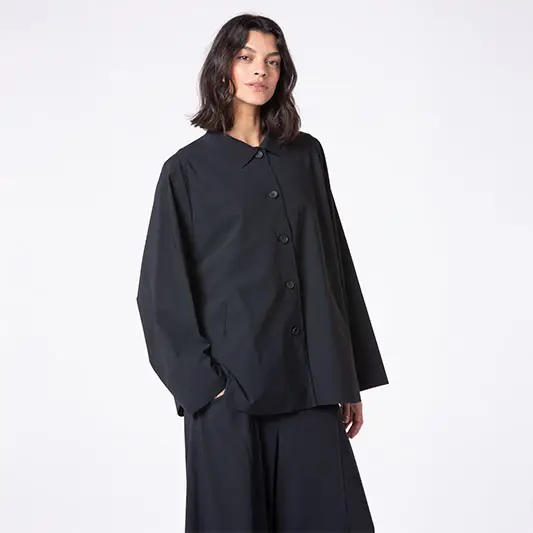 Woman wearing a stylish black button-up jacket.