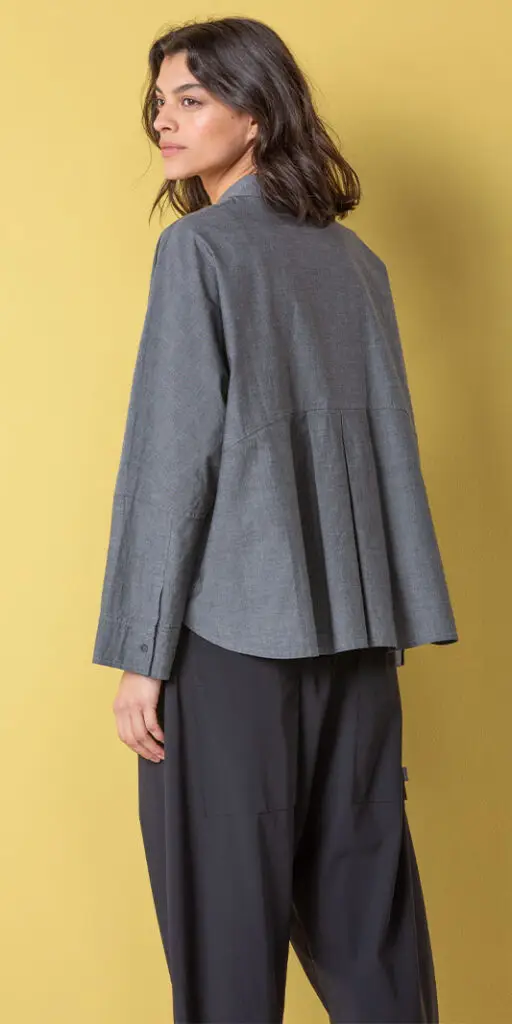 Woman wearing a gray top against yellow background.