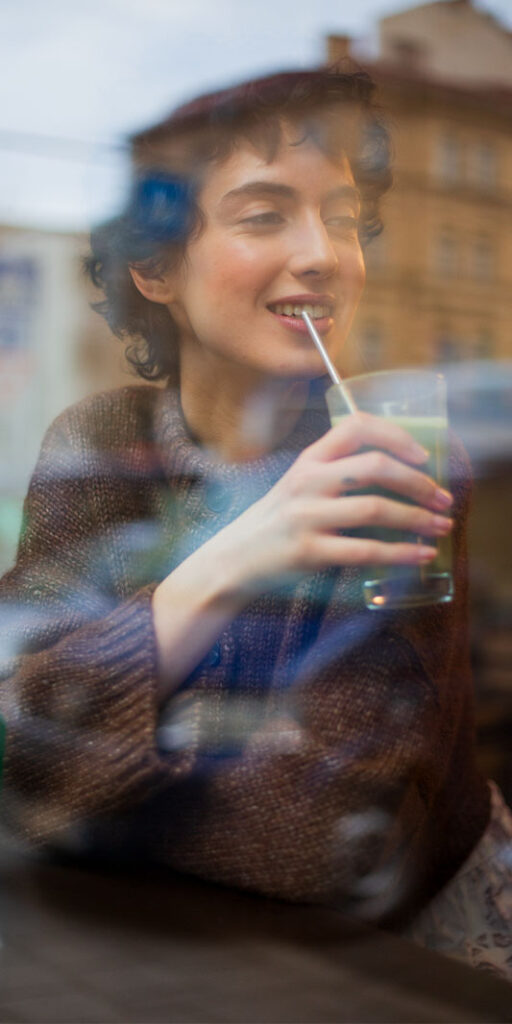 Person enjoying a drink by the window.