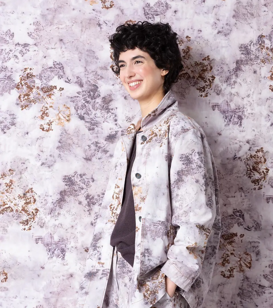 Smiling woman in a stylish patterned jacket.