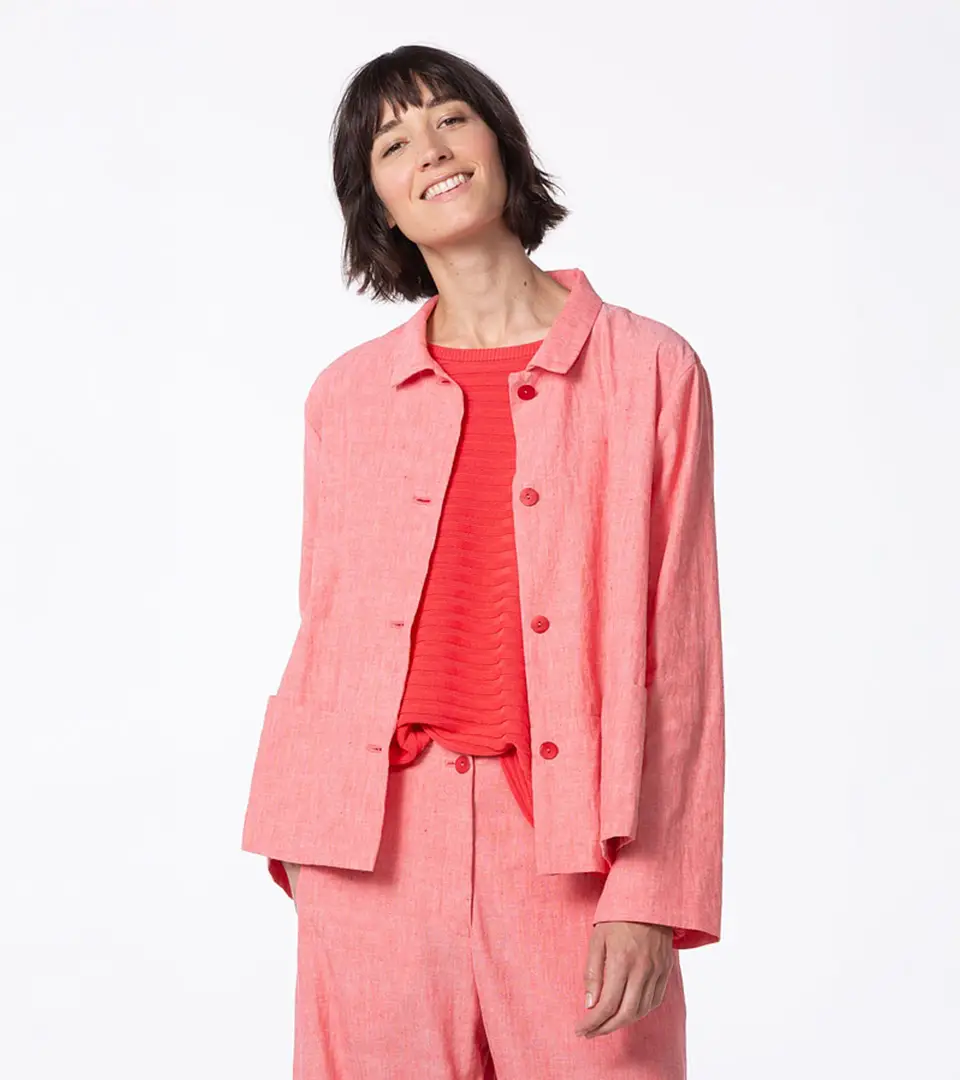 Woman smiling in a pink outfit.