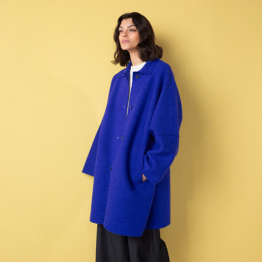 Model wearing a blue oversized coat.