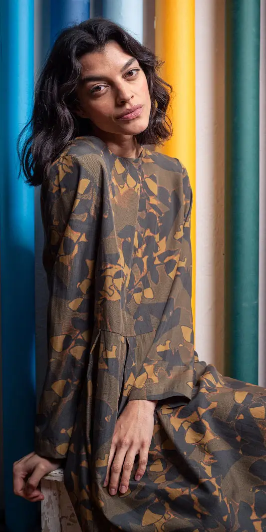 Modèle en robe à motifs sur fond coloré.