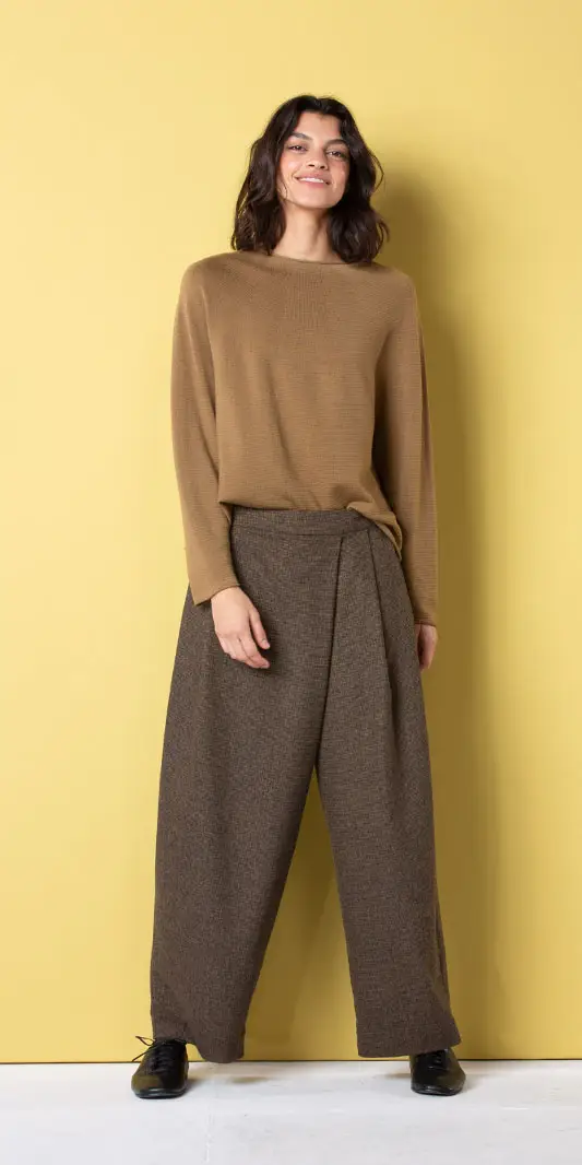Mannequin portant une tenue marron élégante sur fond jaune.