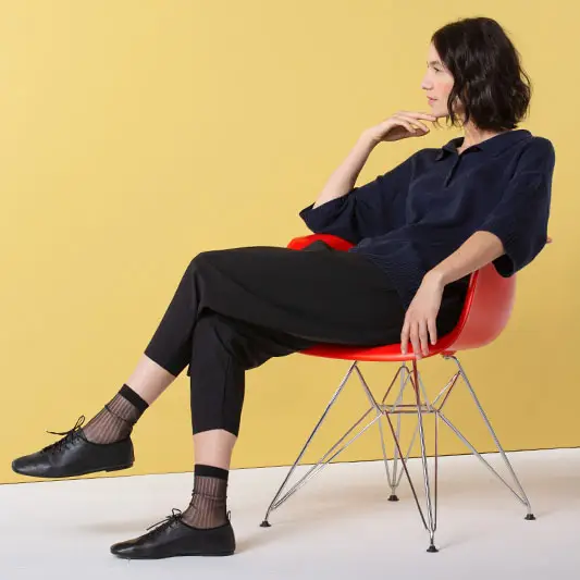 Woman in casual outfit sitting on red chair