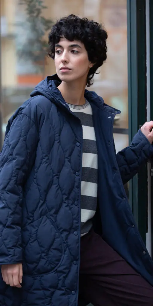 Person wearing a navy blue quilted coat.