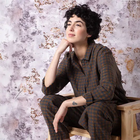 Thoughtful person in a stylish checkered outfit.