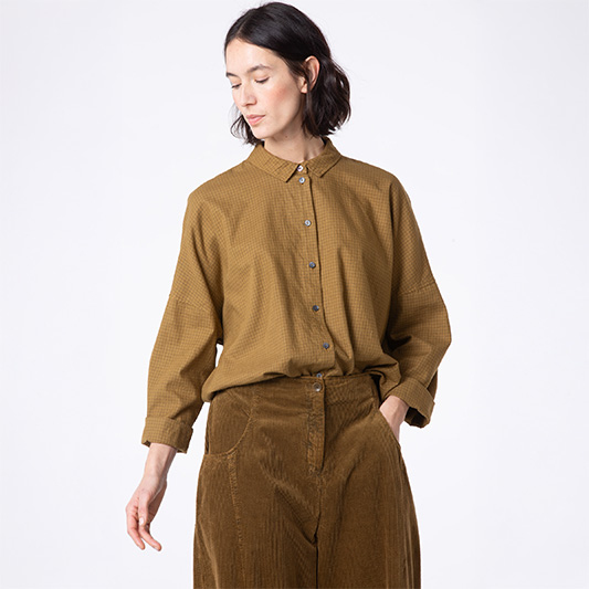 Woman modeling a stylish brown outfit.