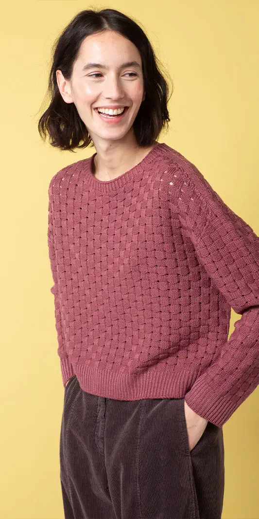 Femme souriante dans un pull rose texturé