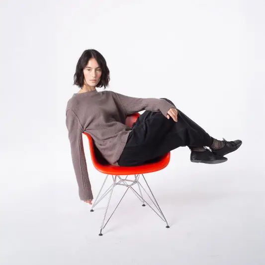Person sitting casually on a modern chair.