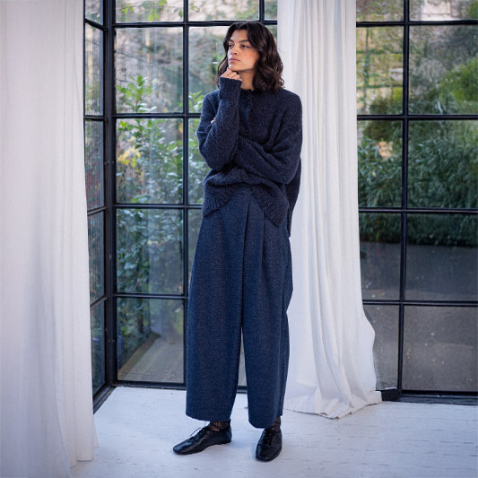 Fashionable woman in cozy attire near window