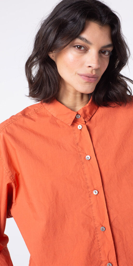 Woman in orange shirt with buttons.
