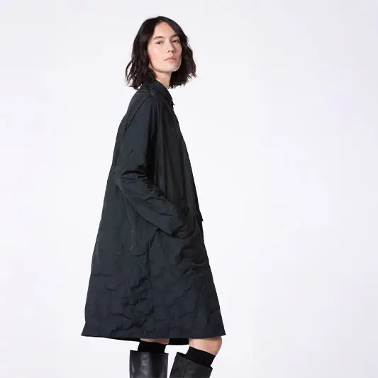 Model wearing a black coat and boots.