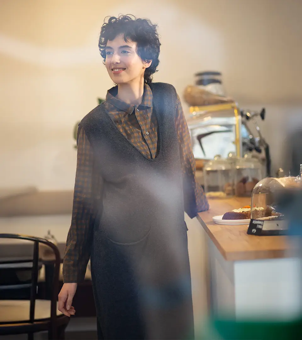 Smiling person in a cozy café setting.