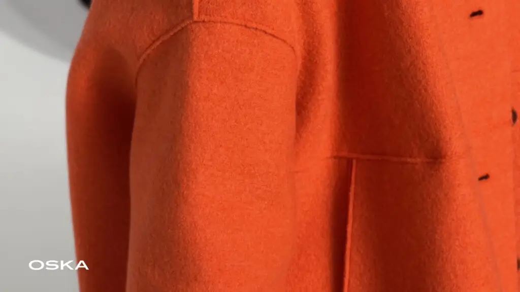 Detail oranžového vlněného kabátu