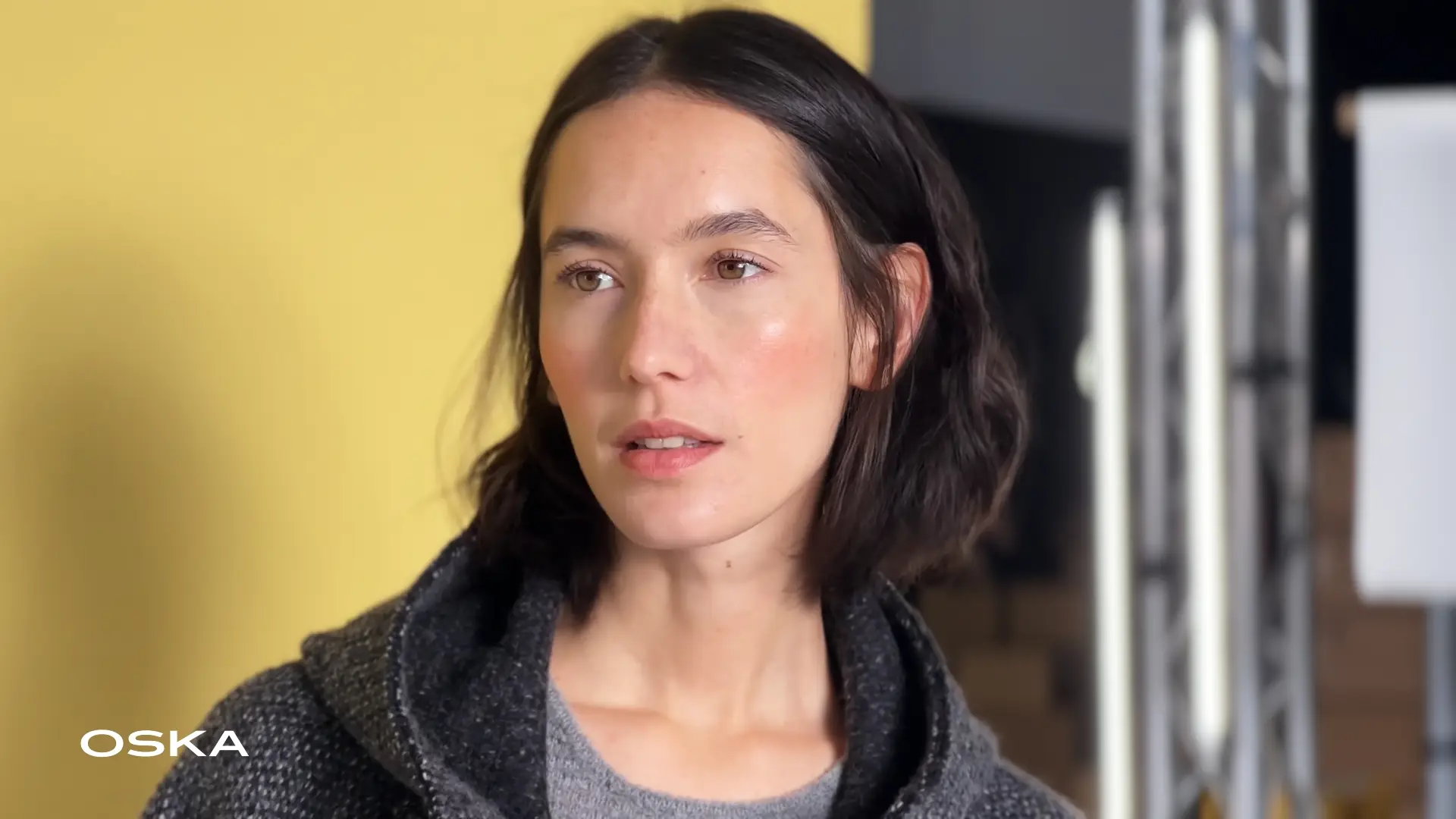 Woman with short hair, wearing a stylish sweater.