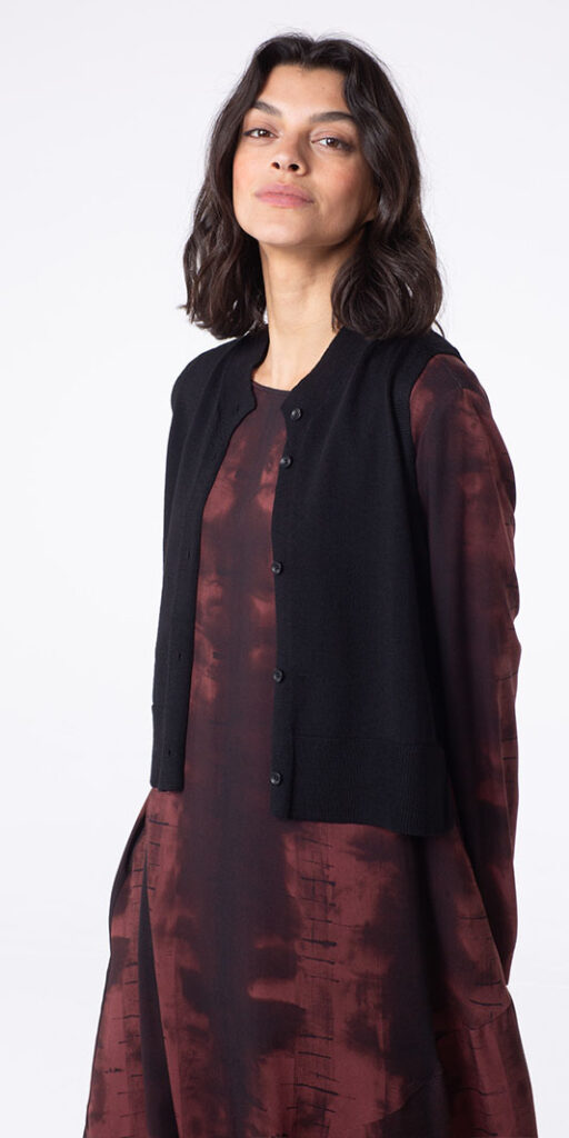 Woman in stylish black vest and dress.