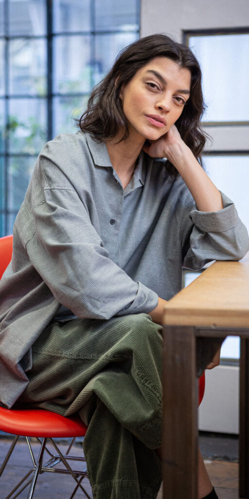 Woman sitting at a table, stylish outfit.