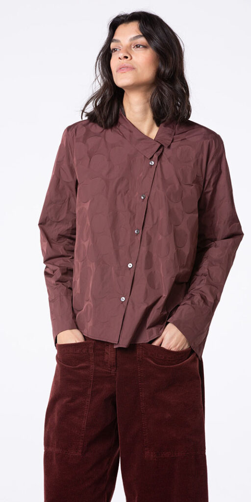 Woman wearing a stylish maroon shirt.