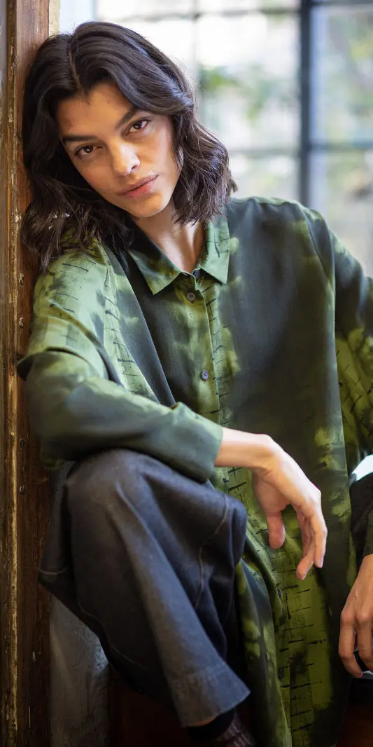 Personne dans une chemise verte élégante posant à l'intérieur.
