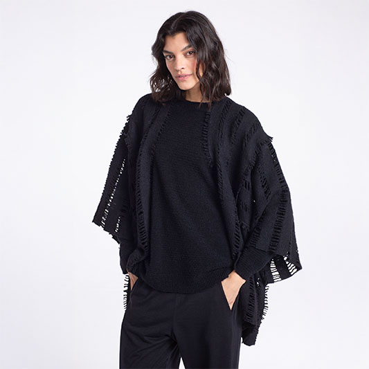Woman in stylish black oversized sweater.