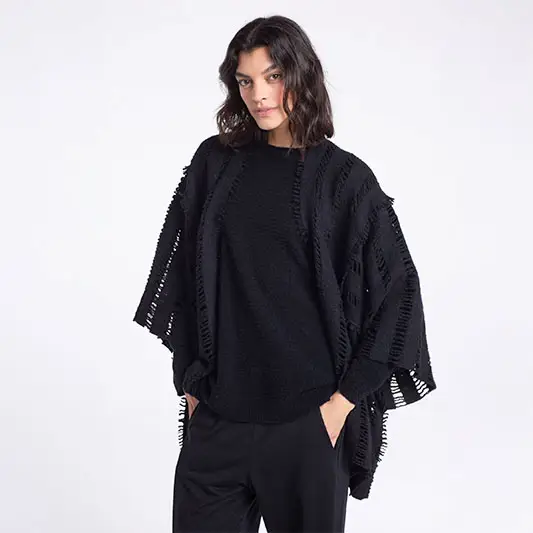 Woman in stylish black oversized sweater.