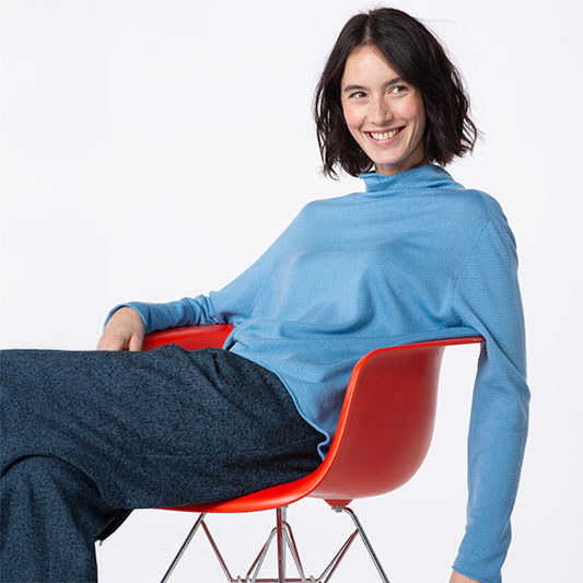 Woman smiling in a blue top and pants.