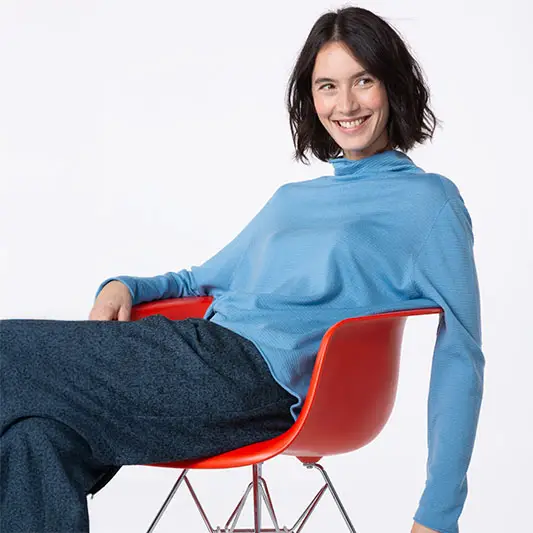 Woman smiling in a blue top and pants.
