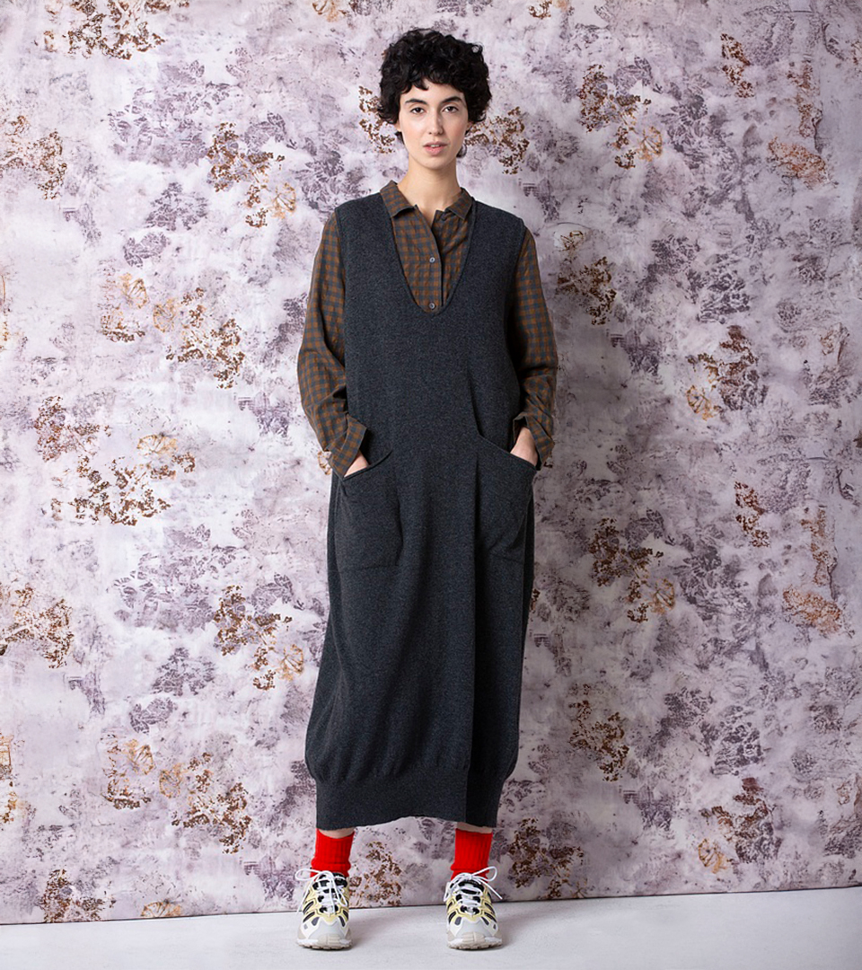 Model wearing a stylish dress with pockets.