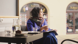 Woman enjoying coffee at a café table.