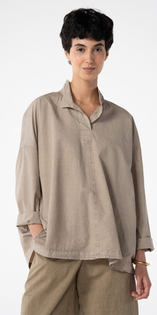 Woman wearing a stylish beige oversized shirt.