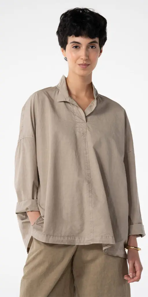 Woman wearing a stylish beige oversized shirt.