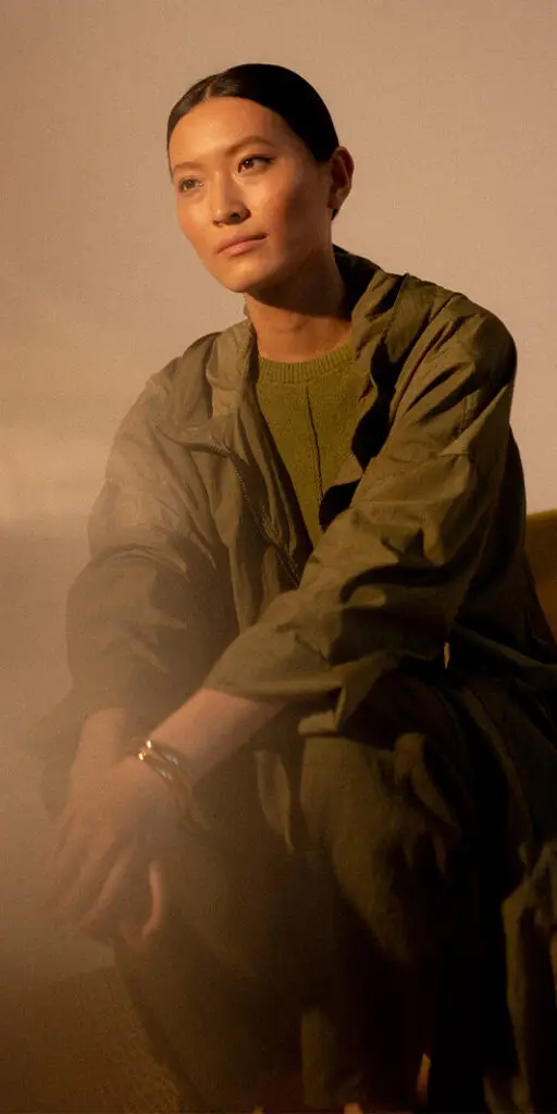 Woman in green attire sitting thoughtfully