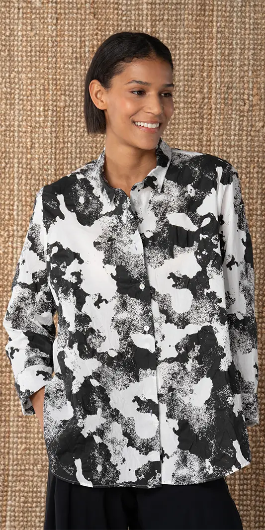 Femme portant une chemise élégante noire et blanche.