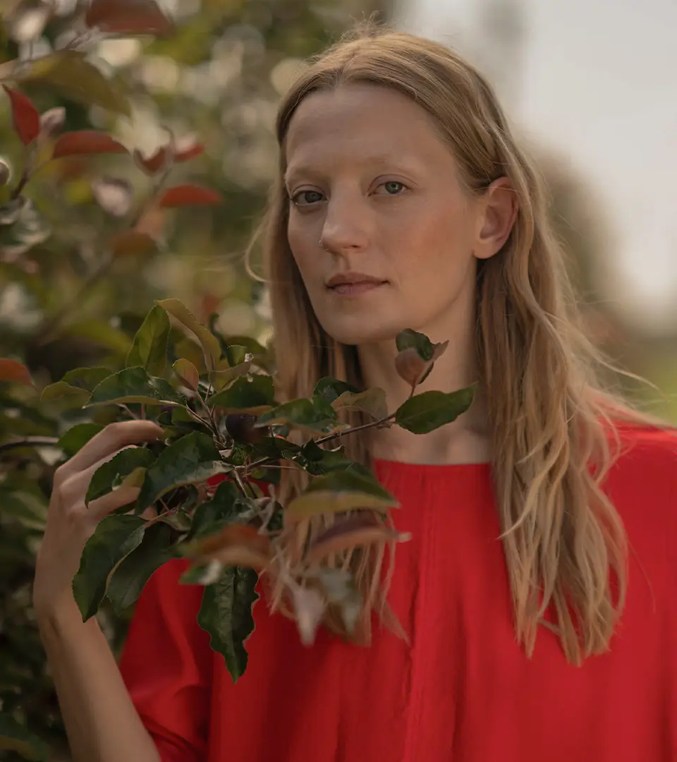 Woman in red shirt holding green leaves