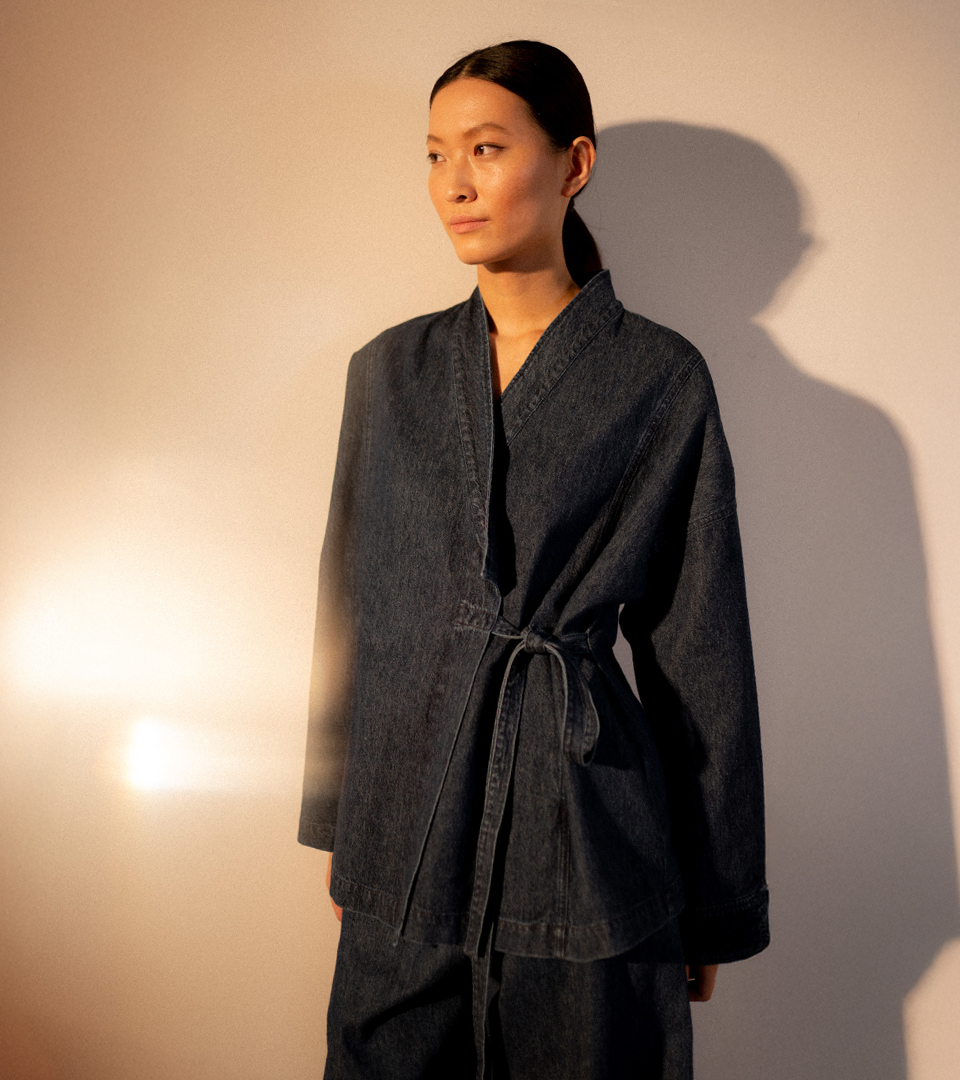 Model in denim outfit with soft lighting