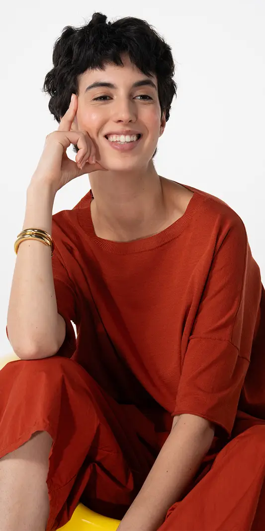 Femme souriante en tenue orange avec un bracelet