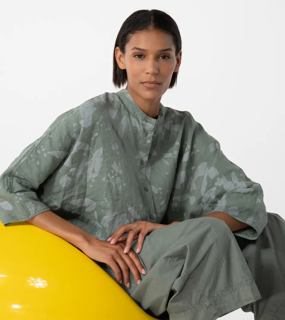 Person in green outfit seated on yellow object