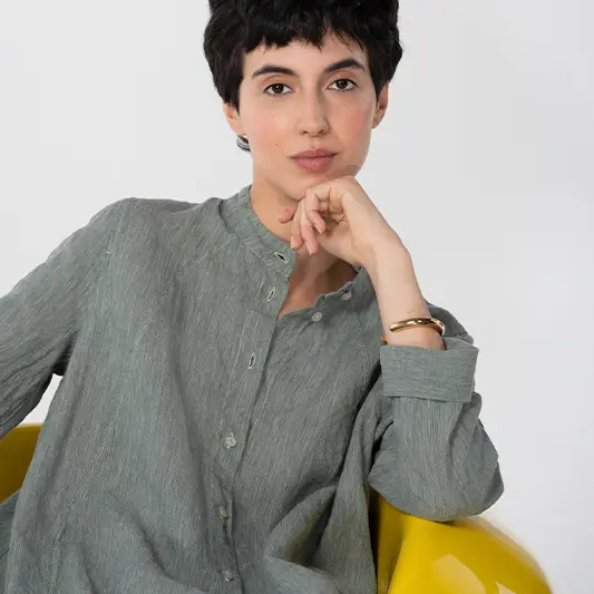 Person in a green shirt sitting on a chair