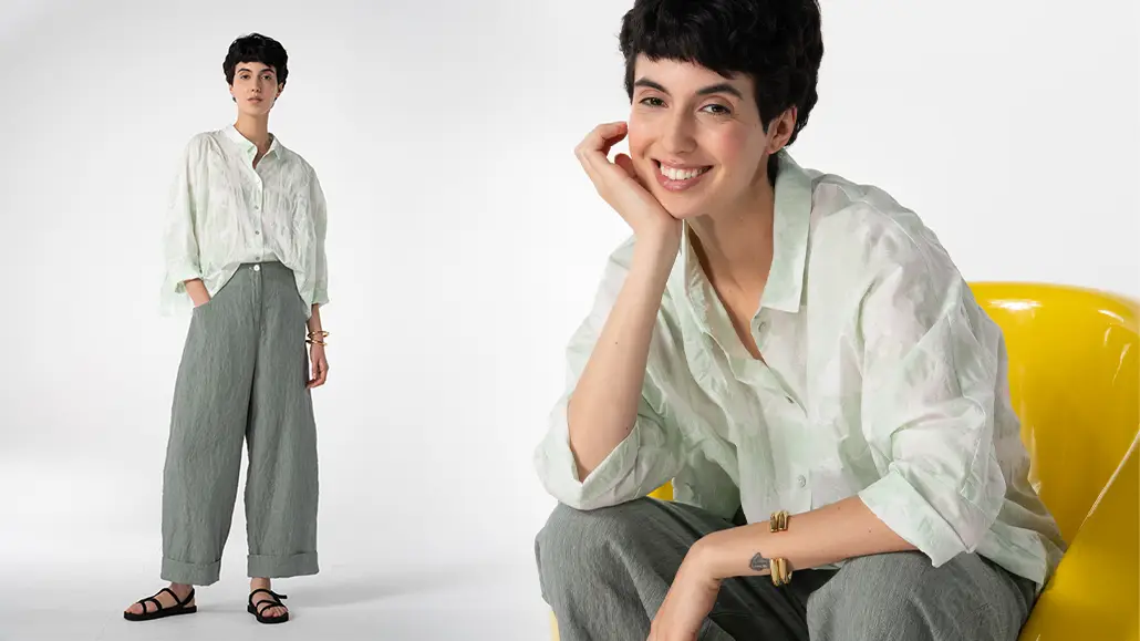 Woman modeling light green blouse and gray pants