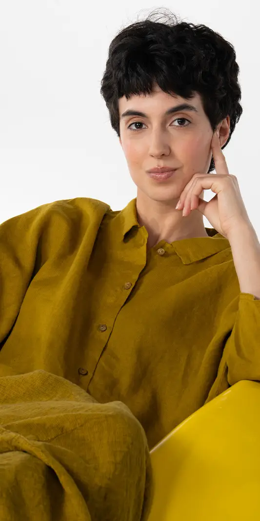 Personne aux cheveux courts portant une chemise moutarde