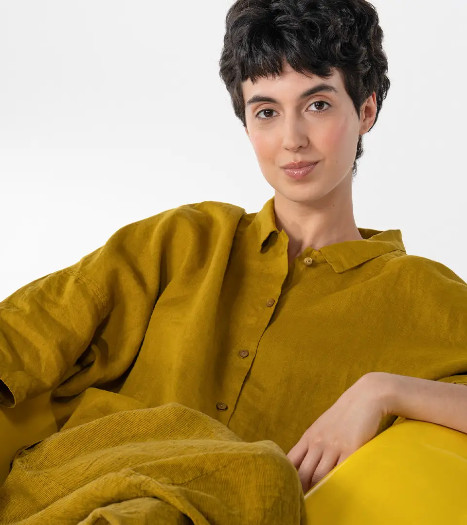 Person in mustard-colored shirt sitting comfortably