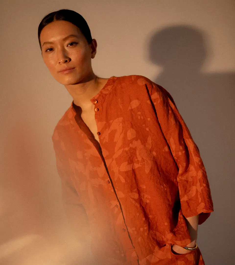 Woman in loose orange blouse with warm lighting